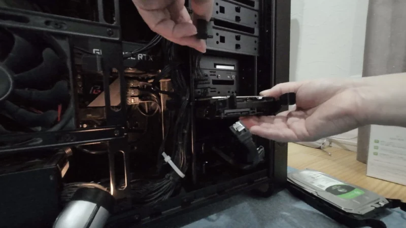 専用ステイに取り付けた新しいHDDをPCケース内の元の場所へスライドさせる様子