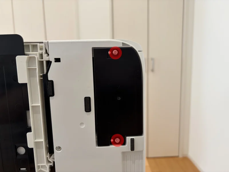 プリンター底面のネジをドライバーで外す様子