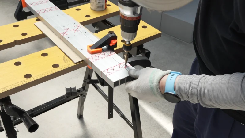 下穴をステップドリルでボルトが通るサイズに拡張する作業